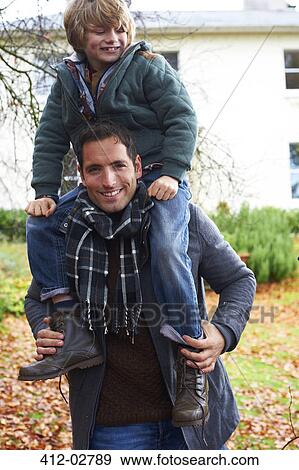 Father carrying son on shoulders outdoors View Large Photo Image Stock Photo - Father carrying son on shoulders outdoors. Fotosearch