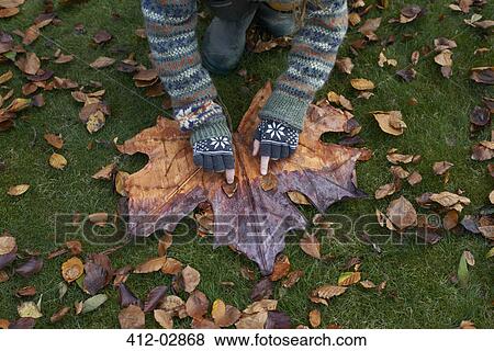 Stock Photo - Girl playing with autumn leaves. Fotosearch