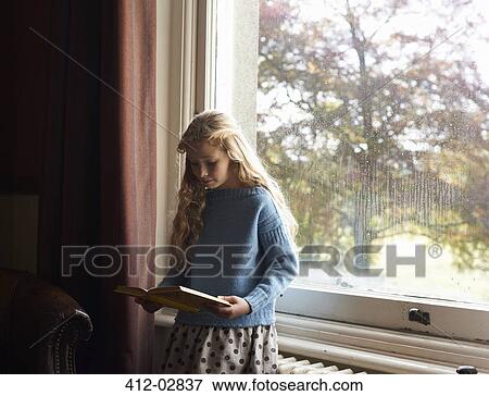 Stock Photo - Girl reading by window. Fotosearch