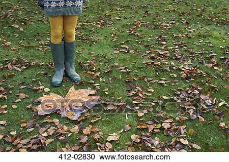 Girl standing by large autumn leaf View Large Photo Image Stock Image - Girl standing by large autumn leaf. Fotosearch