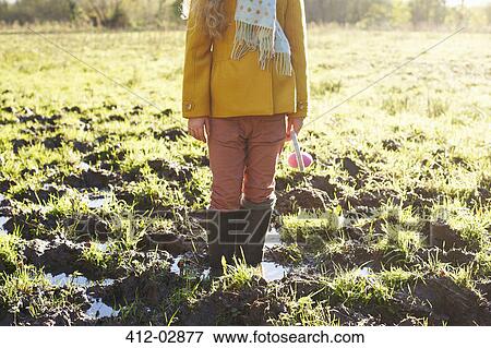 Girl standing in muddy field View Large Photo Image Stock Photo - Girl standing in muddy field. Fotosearch