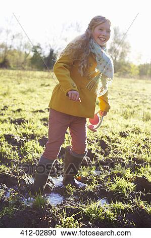 Girl wading in muddy field View Large Photo Image Stock Image - Girl wading in muddy field. Fotosearch