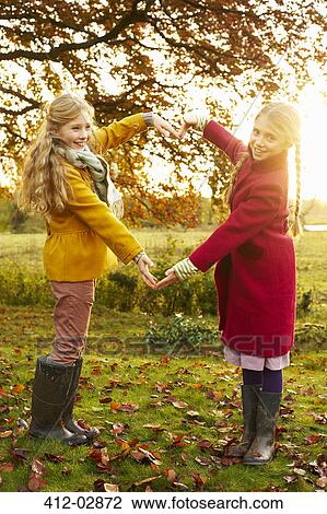 Girls making heart shape with arms outdoors View Large Photo Image Stock Image - Girls making heart shape with arms outdoors. Fotosearch