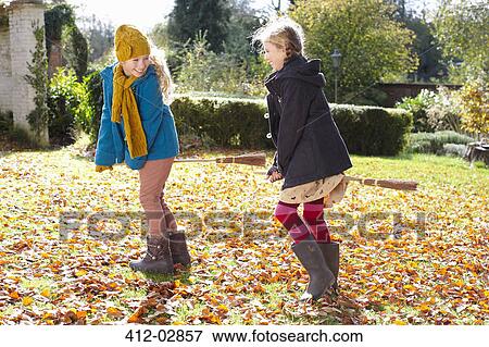Stock Photo - Girls playing together in autumn leaves. Fotosearch