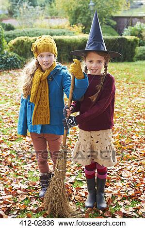 Girls playing with witch's hat and broom outdoors View Large Photo Image Stock Photograph - Girls playing with witch's hat and broom outdoors. Fotosearch