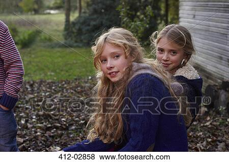 Stock Photo - Smiling girls sitting outdoors. Fotosearch