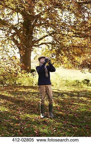 Stock Photography - Teenage boy playing trumpet outdoors. Fotosearch