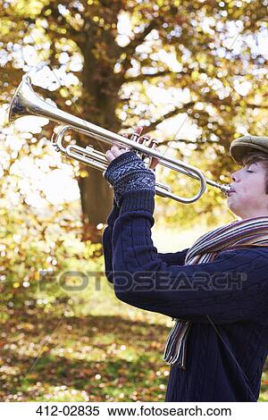 Teenage boy playing trumpet outdoors View Large Photo Image Stock Photography - Teenage boy playing trumpet outdoors. Fotosearch