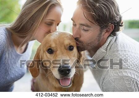 Couple kissing dog indoors View Large Photo Image Stock Image - Couple kissing dog indoors. Fotosearch