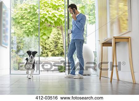 Dog running past man in kitchen View Large Photo Image Stock Photograph - Dog running past man in kitchen. Fotosearch