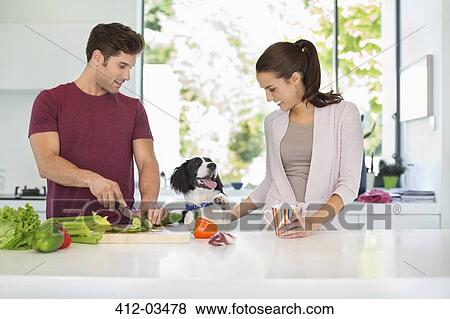 Dog with couple cooking in kitchen View Large Photo Image Stock Photo - Dog with couple cooking in kitchen. Fotosearch