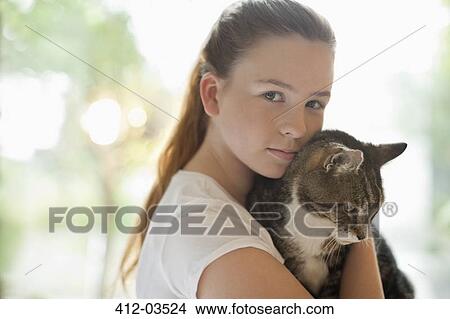 Girl holding cat indoors View Large Photo Image Picture - Girl holding cat indoors. Fotosearch