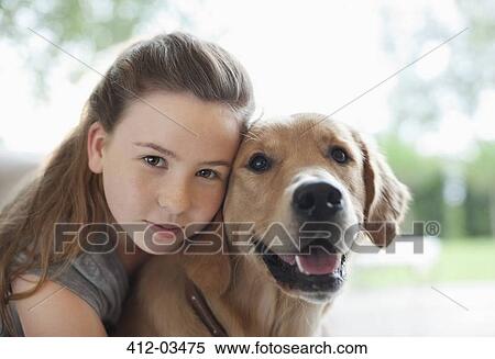 Stock Photography - Girl hugging dog indoors. Fotosearch