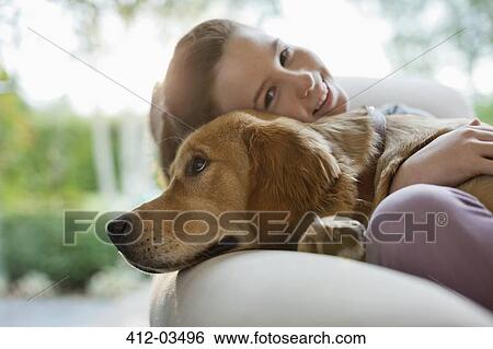 Girl relaxing with dog on sofa View Large Photo Image Stock Photograph - Girl relaxing with dog on sofa. Fotosearch