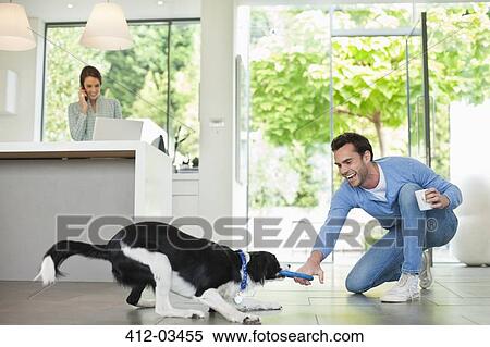 Man playing with dog in kitchen View Large Photo Image Stock Photography - Man playing with dog in kitchen. Fotosearch