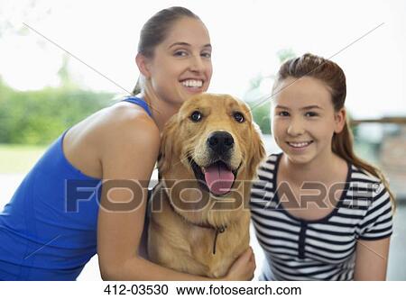 Mother and daughter smiling with dog View Large Photo Image Stock Image - Mother and daughter smiling with dog. Fotosearch