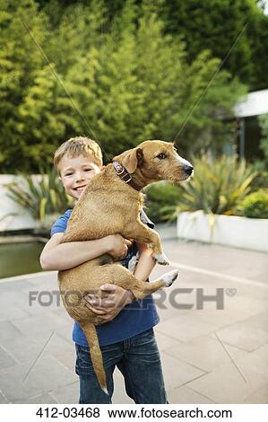 Smiling boy holding dog outdoors View Large Photo Image Stock Photo - Smiling boy holding dog outdoors. Fotosearch