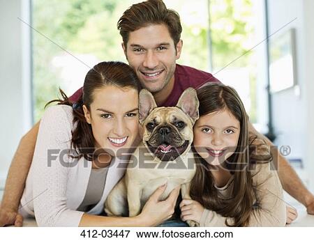 Smiling family hugging dog View Large Photo Image Stock Photo - Smiling family hugging dog. Fotosearch