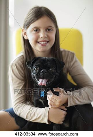 Smiling girl holding dog indoors View Large Photo Image Picture - Smiling girl holding dog indoors. Fotosearch