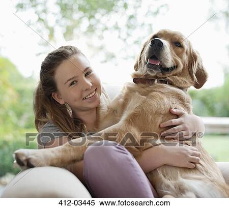 Smiling girl hugging dog on sofa View Large Photo Image Stock Photography - Smiling girl hugging dog on sofa. Fotosearch