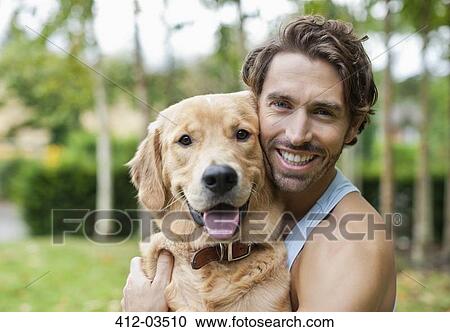 Smiling man petting dog outdoors View Large Photo Image Stock Image - Smiling man petting dog outdoors. Fotosearch