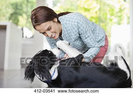Smiling woman playing with dog View Large Photo Image Stock Image - Smiling woman playing with dog. Fotosearch