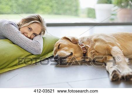 Smiling woman relaxing with dog on floor View Large Photo Image Stock Image - Smiling woman relaxing with dog on floor. Fotosearch
