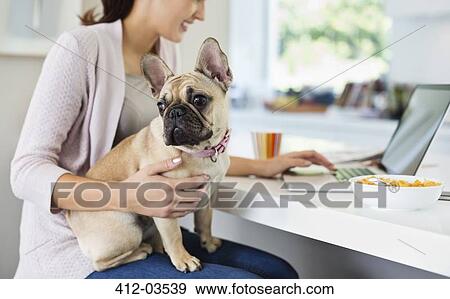 Woman using laptop with dog on lap View Large Photo Image Stock Photo - Woman using laptop with dog on lap. Fotosearch