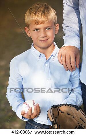 Stock Photo - Boy holding baseball and glove with father. Fotosearch