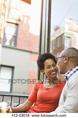 Couple having coffee on city street View Large Photo Image Stock Photo - Couple having coffee on city street. Fotosearch