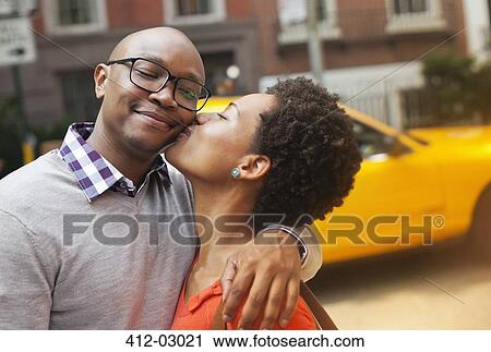 Stock Image - Couple kissing on city street. Fotosearch