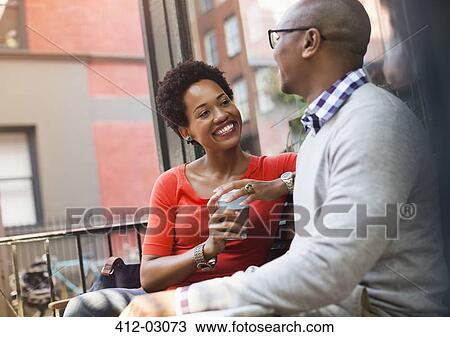 Stock Image - Couple talking on city street. Fotosearch