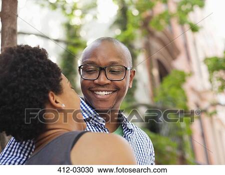 Stock Image - Couple walking together on city street. Fotosearch