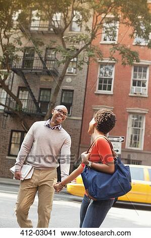 Couple walking together on city street View Large Photo Image Stock Image - Couple walking together on city street. Fotosearch