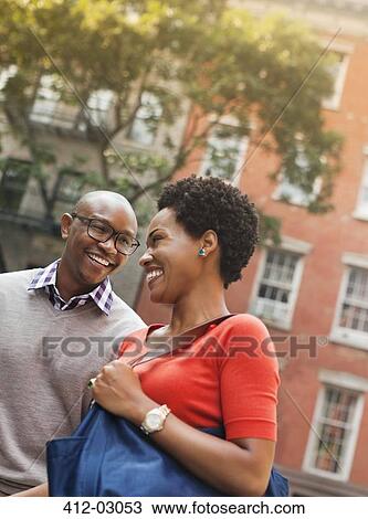 Stock Image - Couple walking together on city street. Fotosearch