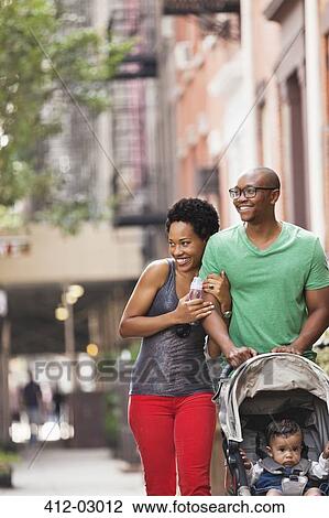 Stock Image - Family walking together on city street. Fotosearch