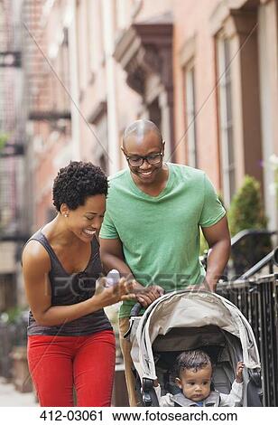 Stock Image - Family walking together on city street. Fotosearch