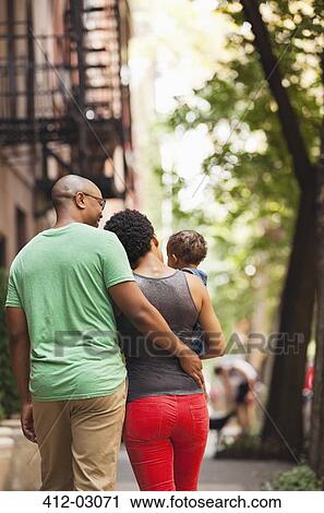Stock Image - Family walking together on city street. Fotosearch