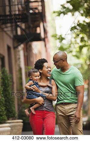 Family walking together on city street View Large Photo Image Stock Image - Family walking together on city street. Fotosearch