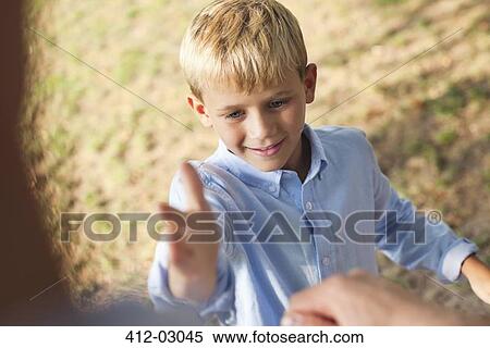 Stock Photography - Father and son high fiving outdoors. Fotosearch