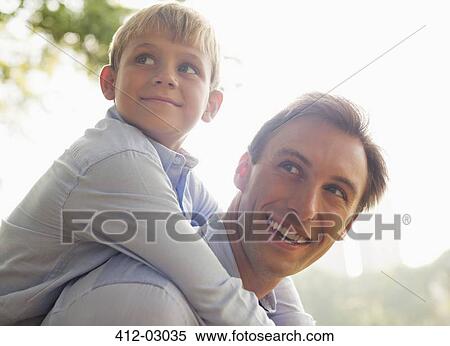 Man carrying son piggyback outdoors View Large Photo Image Stock Photography - Man carrying son piggyback outdoors. Fotosearch