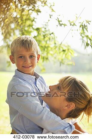 Mother and son hugging in park View Large Photo Image Stock Photo - Mother and son hugging in park. Fotosearch