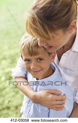 Mother hugging son in park View Large Photo Image Stock Photo - Mother hugging son in park. Fotosearch
