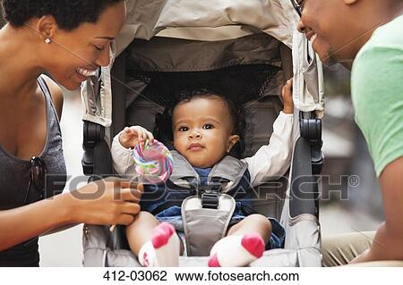 Parents talking to baby in stroller on city street View Large Photo Image Stock Image - Parents talking to baby in stroller on city street. Fotosearch