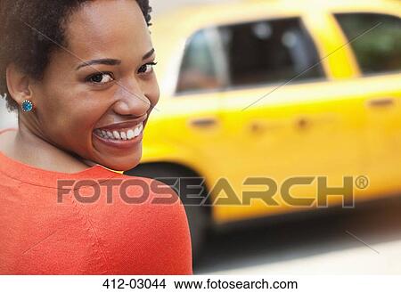 Picture - Woman smiling on city street. Fotosearch
