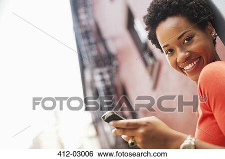 Woman using cell phone outdoors View Large Photo Image Stock Photograph - Woman using cell phone outdoors. Fotosearch