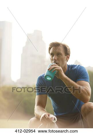 Man drinking water in urban park View Large Photo Image Picture - Man drinking water in urban park. Fotosearch