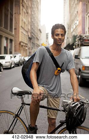 Man on bicycle on city street View Large Photo Image Stock Photo - Man on bicycle on city street. Fotosearch