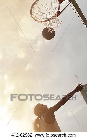 Stock Image - Man playing basketball on court. Fotosearch