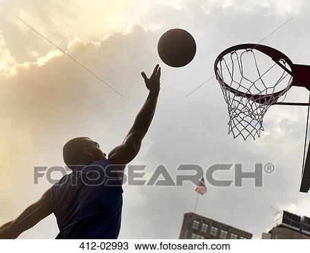 Man playing basketball on court View Large Photo Image Stock Image - Man playing basketball on court. Fotosearch